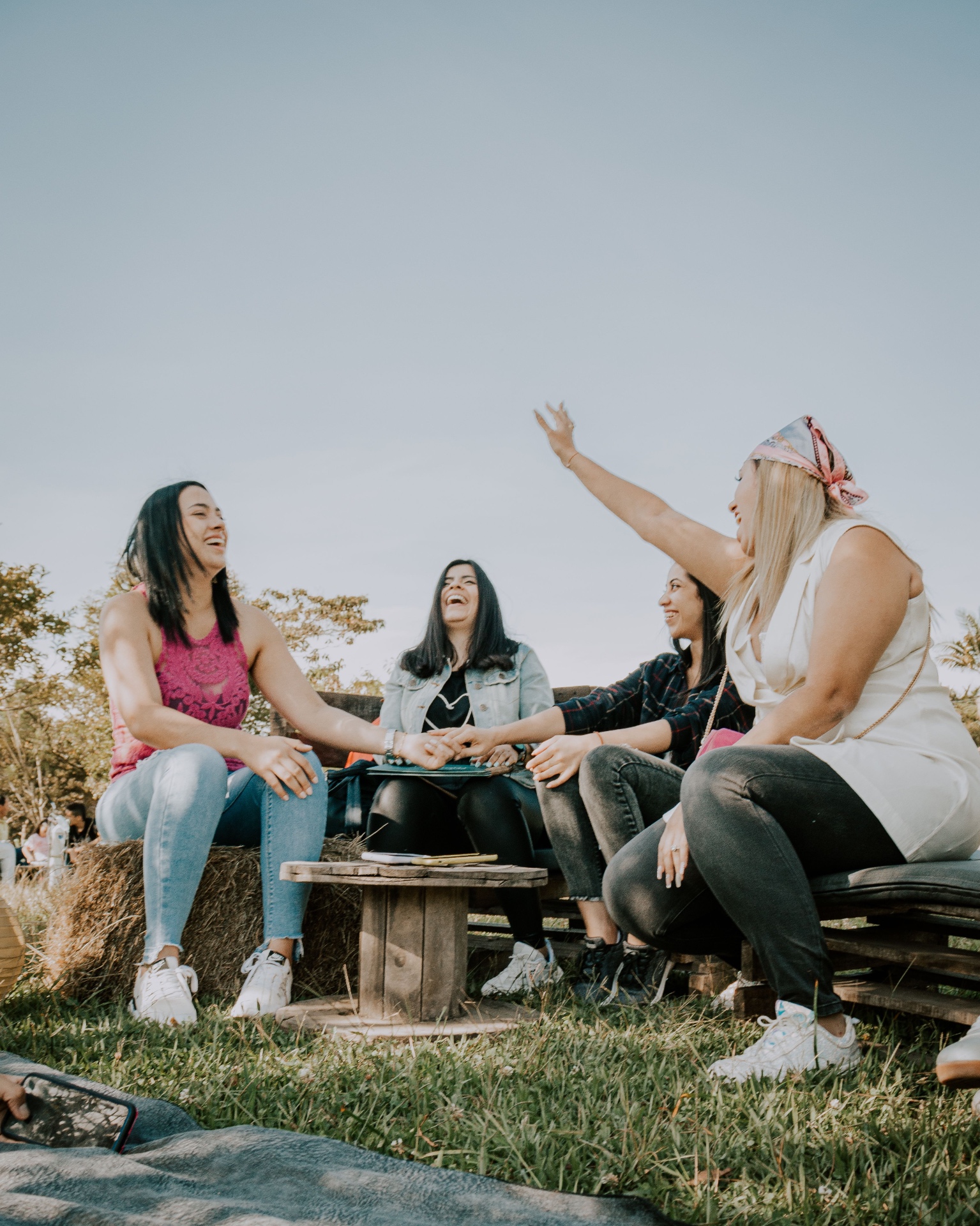 Women gathered around a wooden table with open Bibles in soft natural light